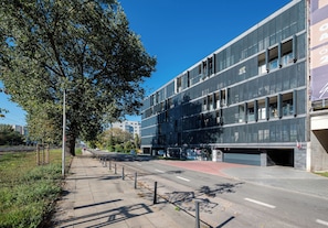 Ein modernes Gebäude mit Glasfassade, einem Fahrradstellplatz und blauem Himmel.