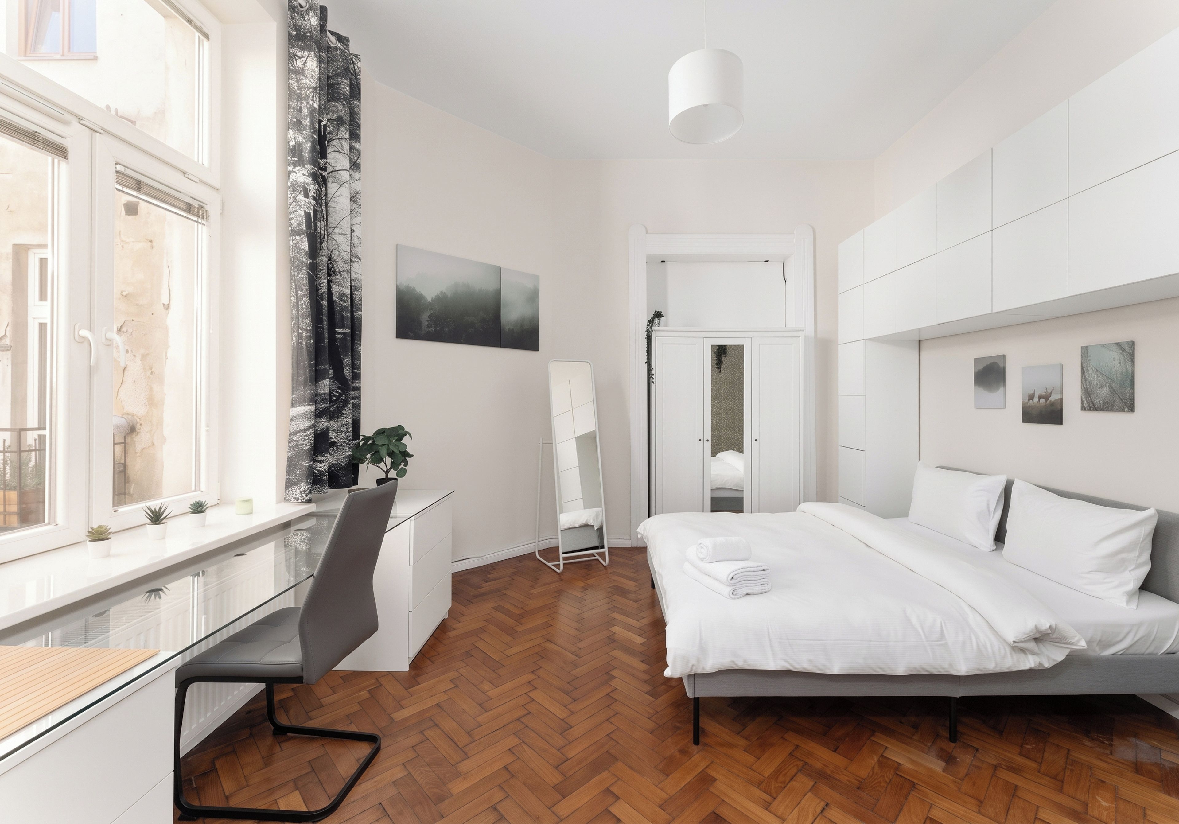 Een moderne slaapkamer met een bed, bureau en stoel.
