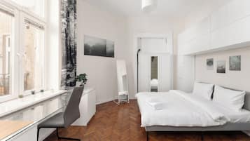 Een moderne slaapkamer met een bed, bureau en stoel.