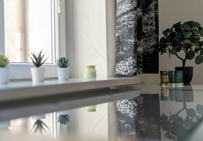 Een schoon, modern interieur met een spiegelende vloer, een raam met planten en een wand met een structuur.