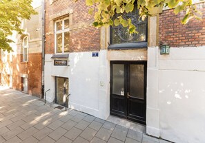 Een gebouw met een bakstenen gevel, een zwarte deur en een bord waarop de naam 'LAB-TECH' staat.