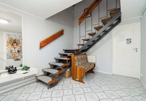 A staircase with wooden steps and metal railings, leading to a landing with a bench. - Piaskowa 57 Homely Apartment (Police)