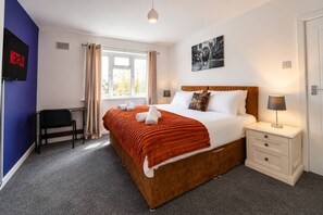 A hotel room with a bed, bedside table, lamp, chair, and a TV screen displaying 'NETFLIX'. - Spacious 4BR Sleeps 10 Free Parking (Cardiff)