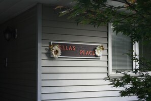 A house exterior with a sign that reads 'ELLA'S PLACE' and decorative flowers. - Downtown Mahomet, IL spacious 4-bedroom ranch house, sleeps 8, near Champaign (Mahomet)