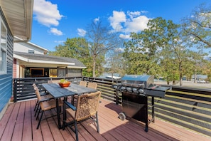 An outdoor deck with a grill, seating area, and a view of a lake. - Table Rock Lakefront Home Near Port of Kimberling_Free Attraction Tickets_Firepit (Kimberling City)
