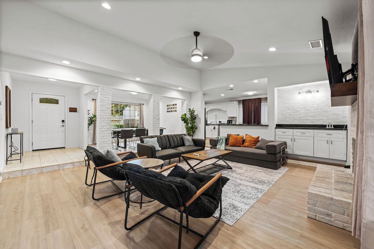 A spacious living area with a sofa, chairs, and a coffee table.