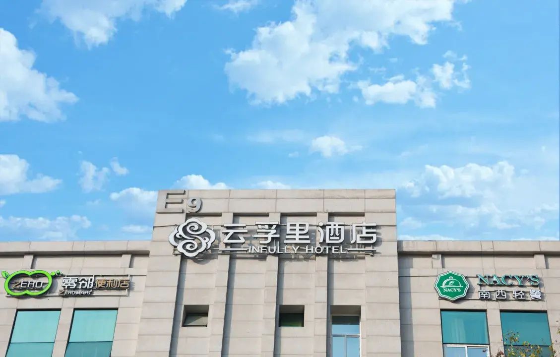 A hotel facade with signage for 'INFULLY HOTEL' and two adjacent establishments with green logos.