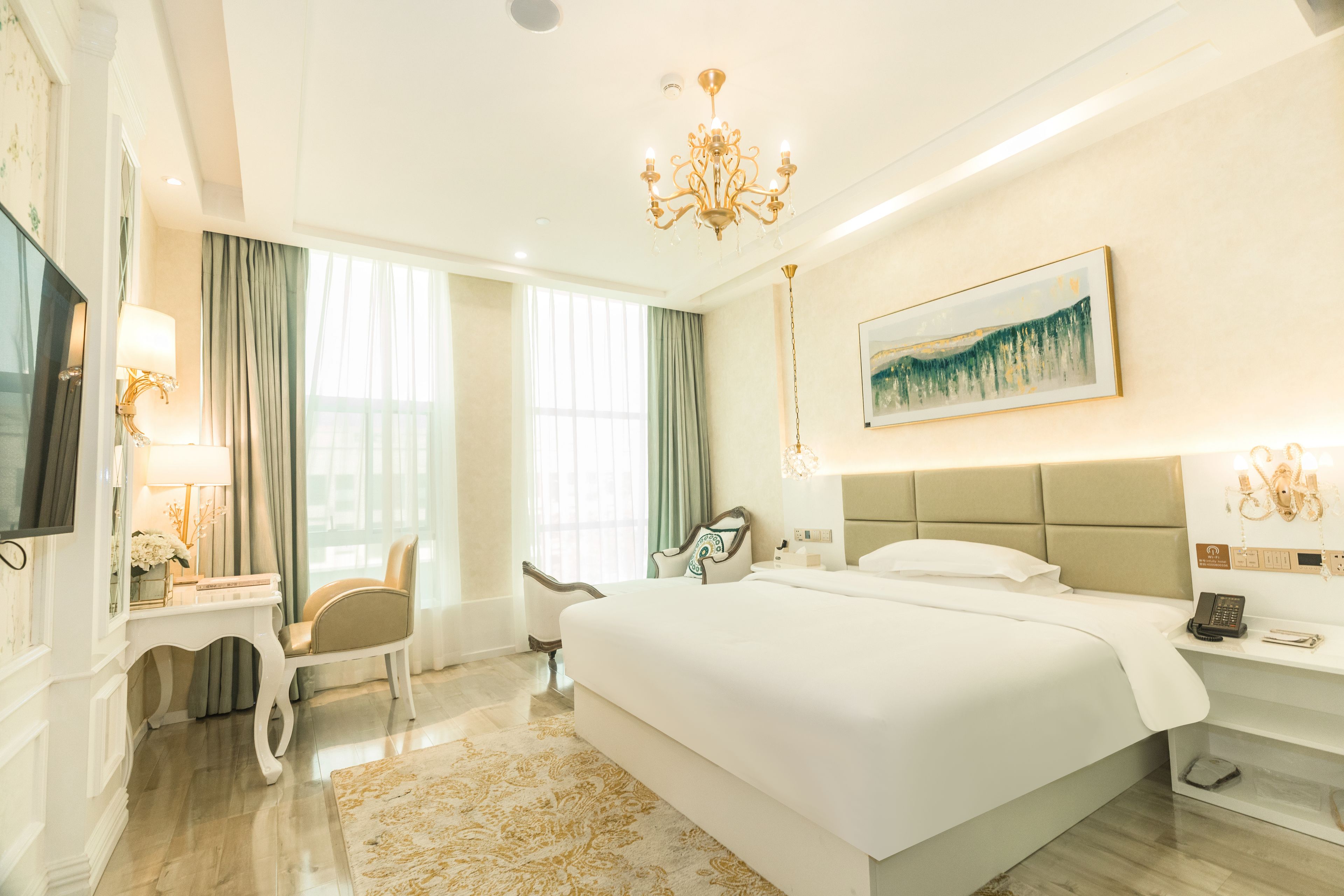 A hotel room with a large bed, a flat-screen TV, a desk with a lamp, and a painting on the wall.