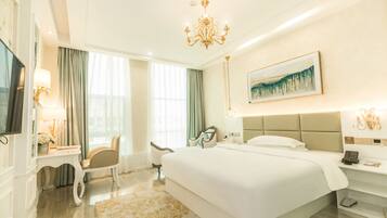 A hotel room with a large bed, a flat-screen TV, a desk with a lamp, and a painting on the wall.