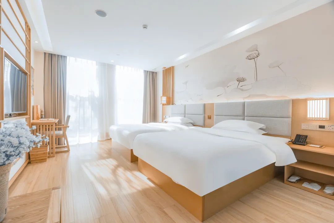 Una habitación de hotel moderna con una cama grande, mesitas de noche, un escritorio y una silla.
