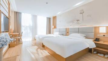 Una habitación de hotel moderna con una cama grande, mesitas de noche, un escritorio y una silla.
