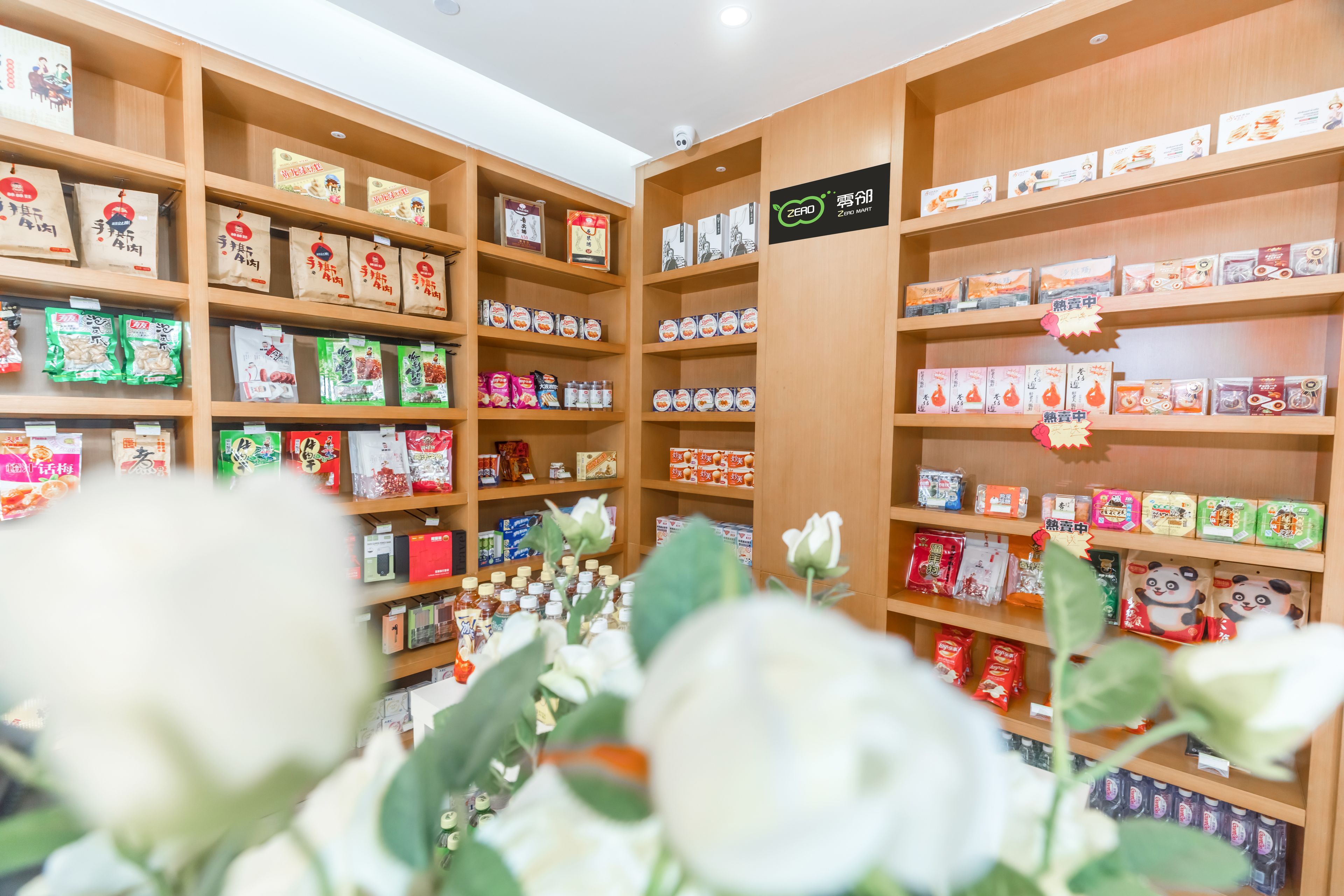 Una tienda con estantes llenos de diversos productos envasados, incluyendo aperitivos y bebidas.