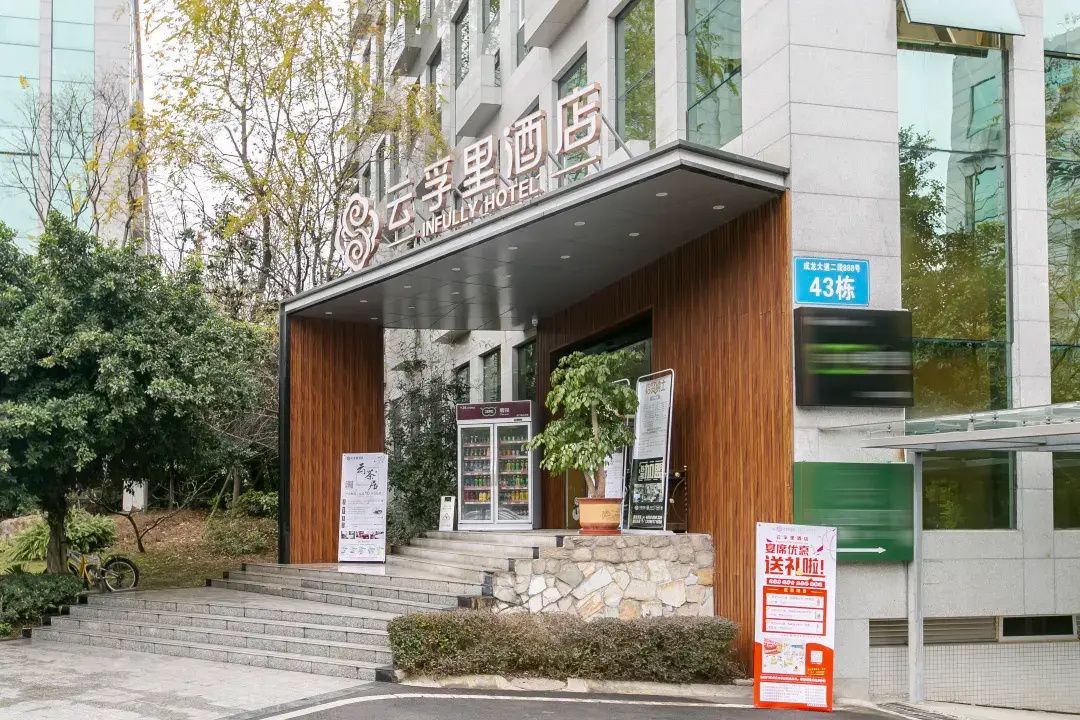 Ein Hotel mit moderner Fassade, eine Treppe zum Eingang und ein Schild mit der Zimmernummer 43.