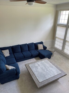 A living room with a sectional sofa, a coffee table, and a ceiling fan. - Excellent 5-bed room close to airport & downtown in charming Kansas City suburb (Kansas City)