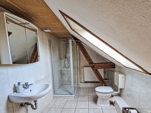 A modern bathroom with a shower, toilet, and sink. - mit zwei Doppel- und einem Einzelzimmer, Essküche, Vollbad und Balkon by Interhome (Küstriner Vorland)