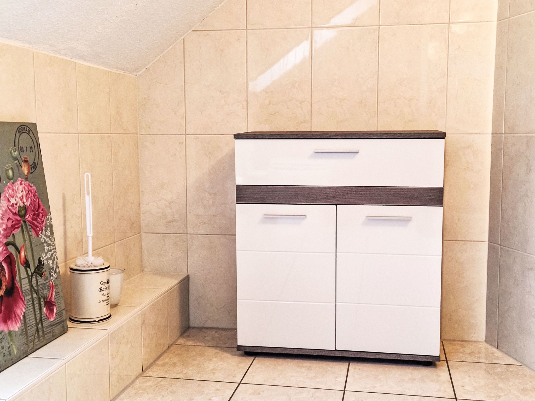 Une salle de bain avec un meuble blanc, des toilettes et un lavabo.