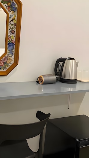 Une cuisine moderne équipée d’une bouilloire, d’un thermos et d’un crédence décorative en carreaux.