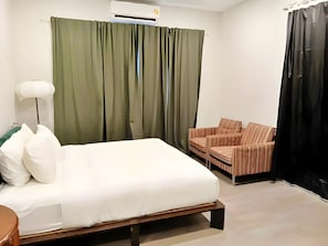 A hotel room with a bed, a chair, a lamp, and a curtain. - H room Yaowarat (Sampunthawong)