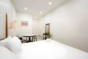 A hotel room with a bed, a round table, a chair, a lamp, a mirror, and a framed picture on the wall. - H room Yaowarat (Sampunthawong)