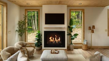 Cozy up by the fireplace after a day exploring Shenandoah, with peaceful forest views just beyond the windows