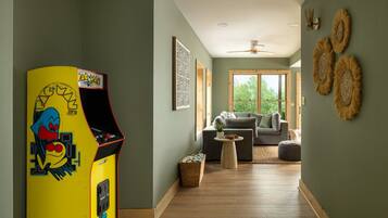A playful lower-level game lounge brings everyone together with classic arcade fun and plenty of room to unwind.