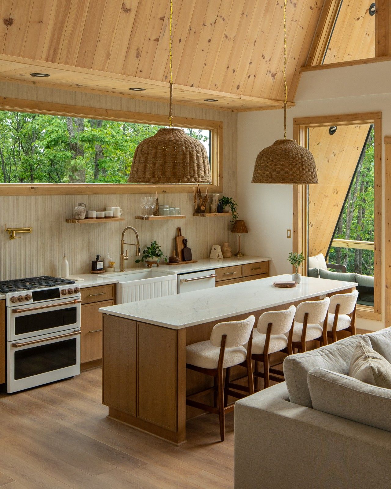 A modern kitchen with wooden cabinets, a central island, and a dining area with chairs.