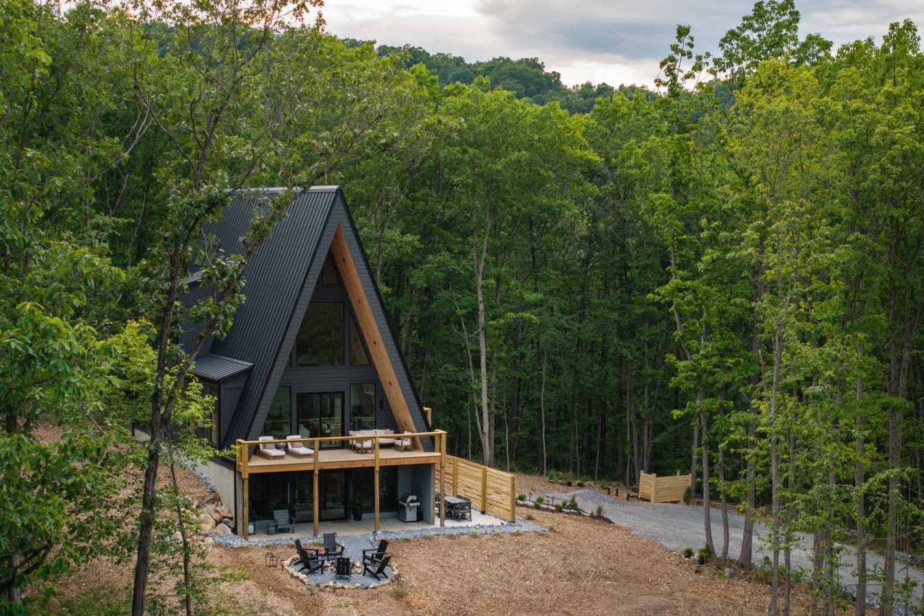 Une cabane moderne, dotée d’un toit en pente, entourée d’une forêt dense.