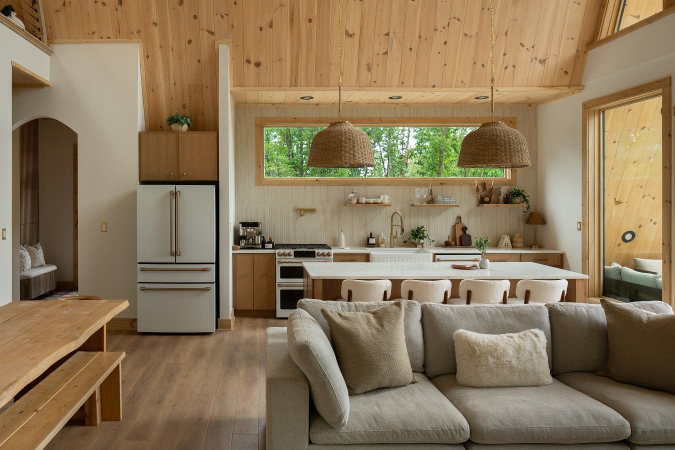 Una cocina moderna con armarios de madera, una isla central e iluminación colgante.