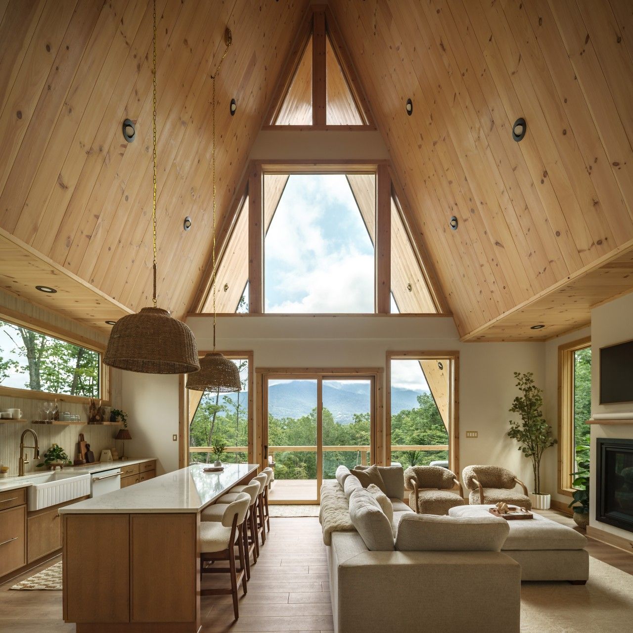 A spacious loft with a high ceiling, large windows, a central island, and a cozy seating area.
