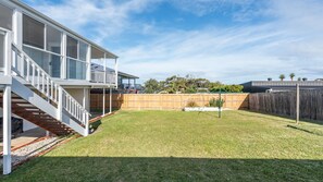 A two-story house with a covered balcony and a fenced backyard. - Mollymere Coastal Retreat in Mollymook Beach (Mollymook Beach)