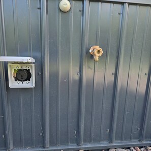 A metal wall with a utility box and a valve. - Not Your Average Driveway (Duluth)