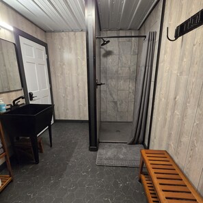 A bathroom with a shower, a sink, and a bench. - Not Your Average Driveway (Duluth)