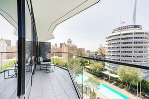 A balcony with a view of a cityscape, including a building labeled 'CAPITAL RECORDS.' - Landing | Incredible 1BD in Hollywood (Los Angeles)