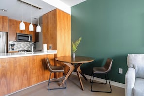 Eine moderne Küche mit Holzschränken, Edelstahlgeräten und Pendelleuchten.
