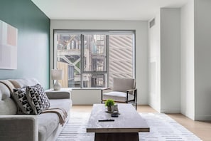A modern living room with a sofa, armchair, and coffee table. - Landing | Incredible 1BD, Gym, Rooftop Lounge (Los Angeles)