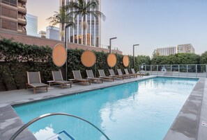 A swimming pool with lounge chairs and a lifeguard stand. - Landing | Beautiful 1BD, Rooftop Lounge, Gym (Los Angeles)