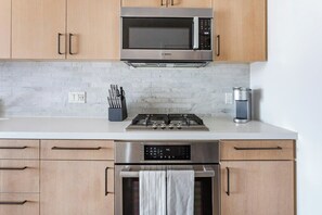 A kitchen with a Bosch microwave, a gas stove, and stainless steel appliances. - Landing | Chic Studio in Hollywood (Los Angeles)