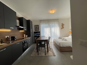 Ein gemütlicher Wohnbereich mit Küchenzeile, Essplatz und Schlafzimmer.