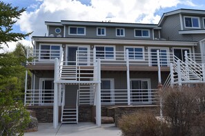 A two-story building with a stone foundation, multiple windows, and a white exterior. - Your Ultimate Bear Lake Lakeside Escape! (Garden City)