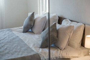 A neatly made bed with a patterned bedspread and several pillows. - Villa with private swimming pool (Poreč)