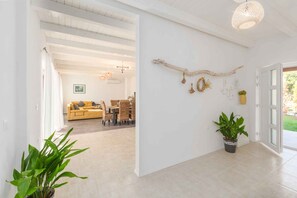 Un intérieur moderne comprenant un espace de vie, un coin repas et un couloir menant à une porte.