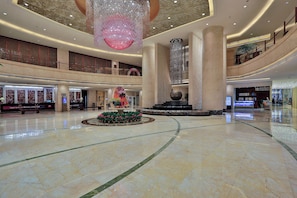 A spacious lobby with a central fountain, marble flooring, and a high ceiling with decorative lighting. - Shaoxing Tianma Grand Hotel (Shaoxing)