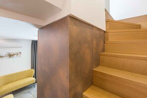 Een trap met houten treden en een bruine muur.