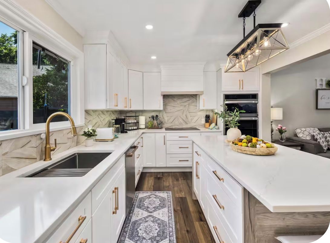 A modern kitchen with white cabinetry, a central island, and a built-in oven.