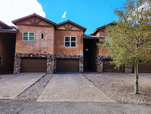 A two-story house with a stone facade, two garage doors, and a paved driveway. - Black Diamond Lakeview Retreat, Ski In/Out + Hot Tub (Brian Head)