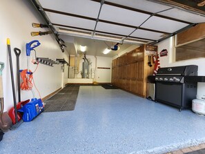Un garage avec un sol bleu, une grille noire et un panneau indiquant qu’il est interdit de camper sur place la nuit.