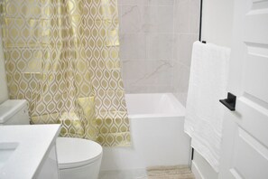 Ein Badezimmer mit Toilette, Badewanne und Duschvorhang.