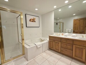 Une salle de bain moderne avec une douche à parois de verre, une baignoire sur pieds et des meubles de rangement en bois.