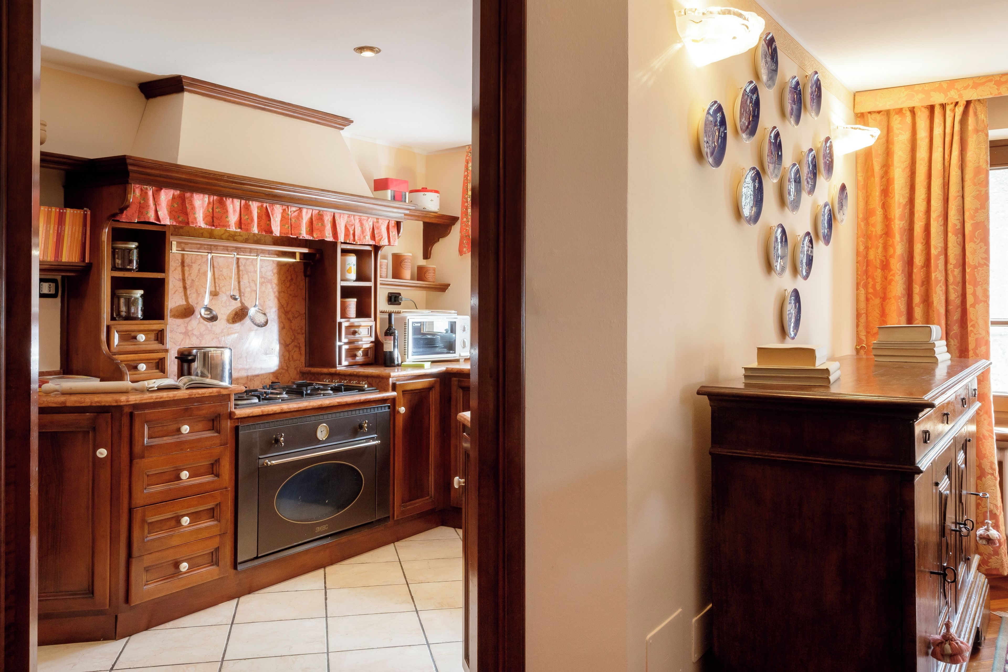 Una cocina con armarios de madera, estufa y microondas.