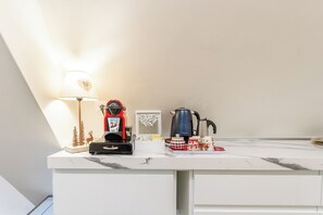 Eine Küchenarbeitsplatte mit Kaffeemaschine, Wasserkocher und einer Dekoration.